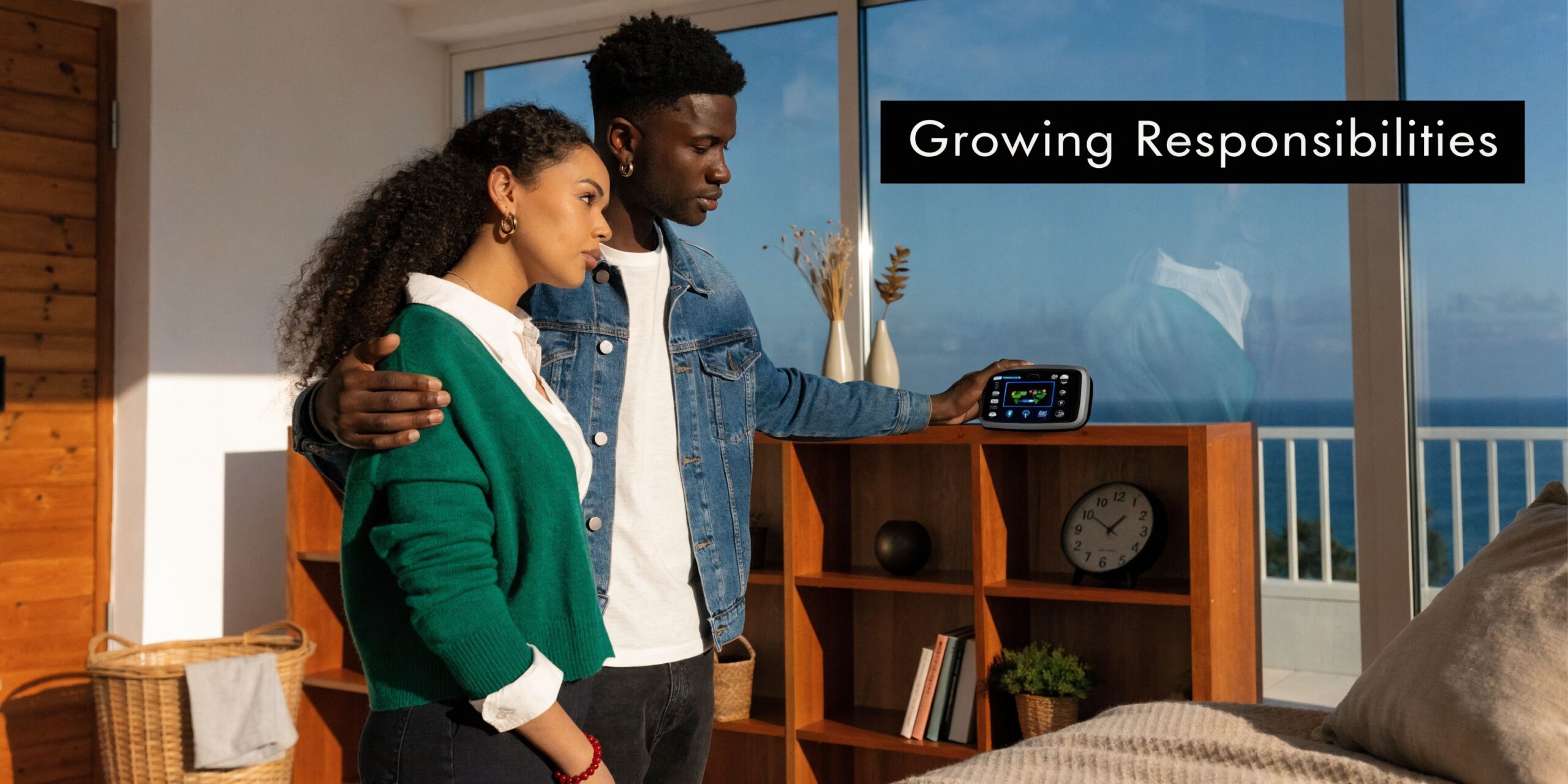 A young couple stands together by a window looking at a home automation control panel device.