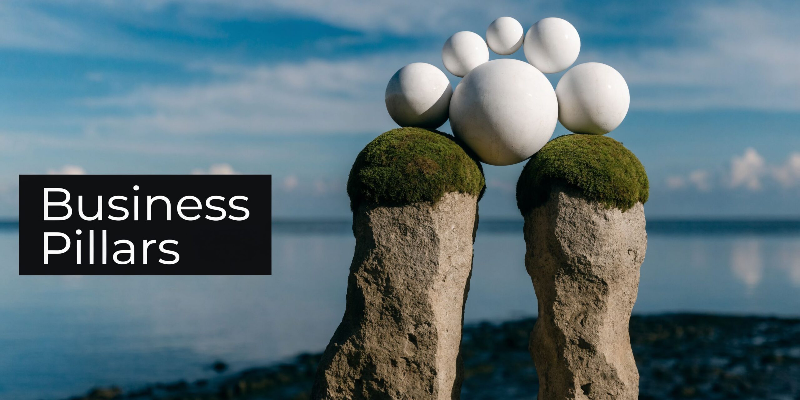 A conceptual image showing large white spheres balanced on top of mossy rock pillars against a blue sky.