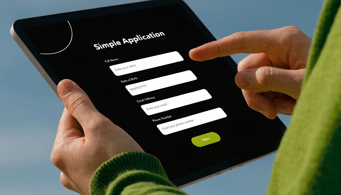 A person using a digital tablet to fill out an online application form with personal details.