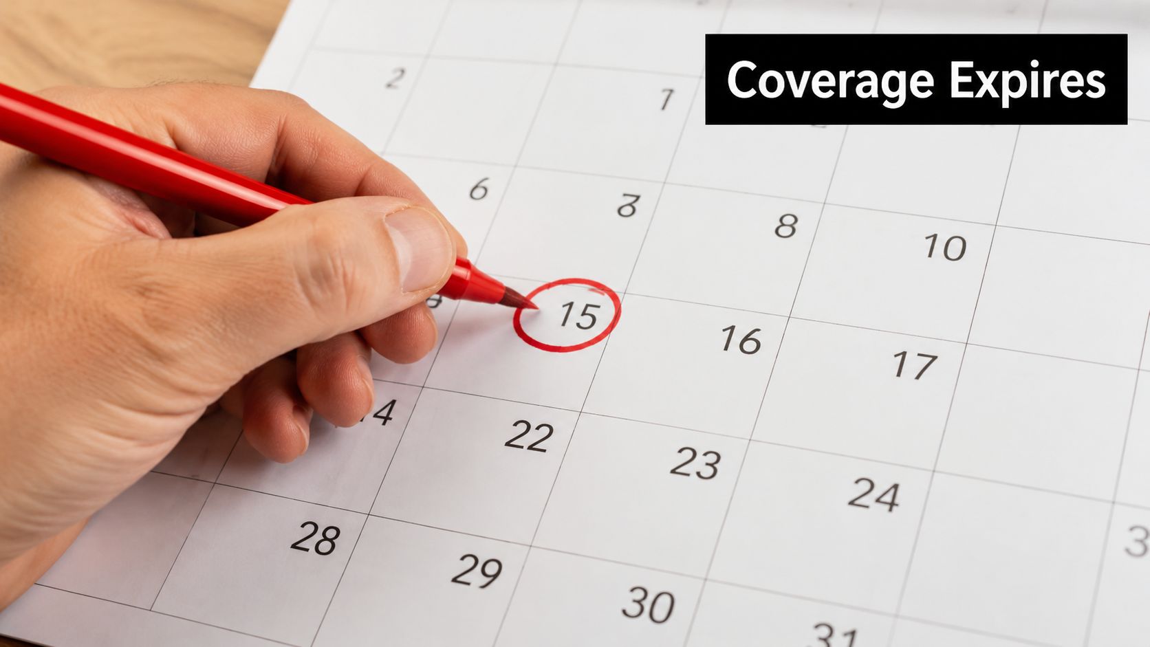 A hand holding a red marker circling the date 15 on a paper calendar for insurance planning.